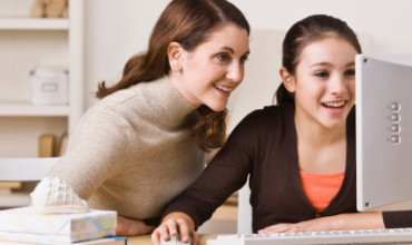 Mother on Daughter on Computer