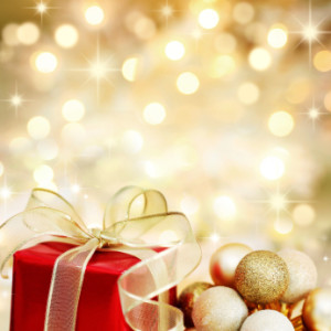 Christmas gift and baubles on defocused lights background